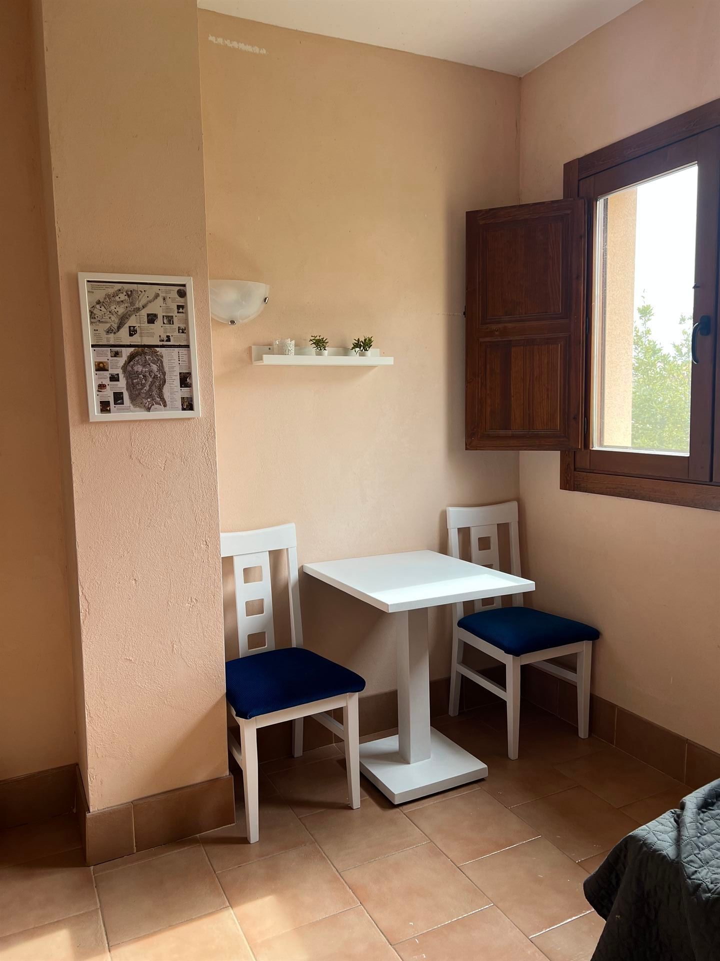 Una habitación con una mesa y sillas y una ventana.