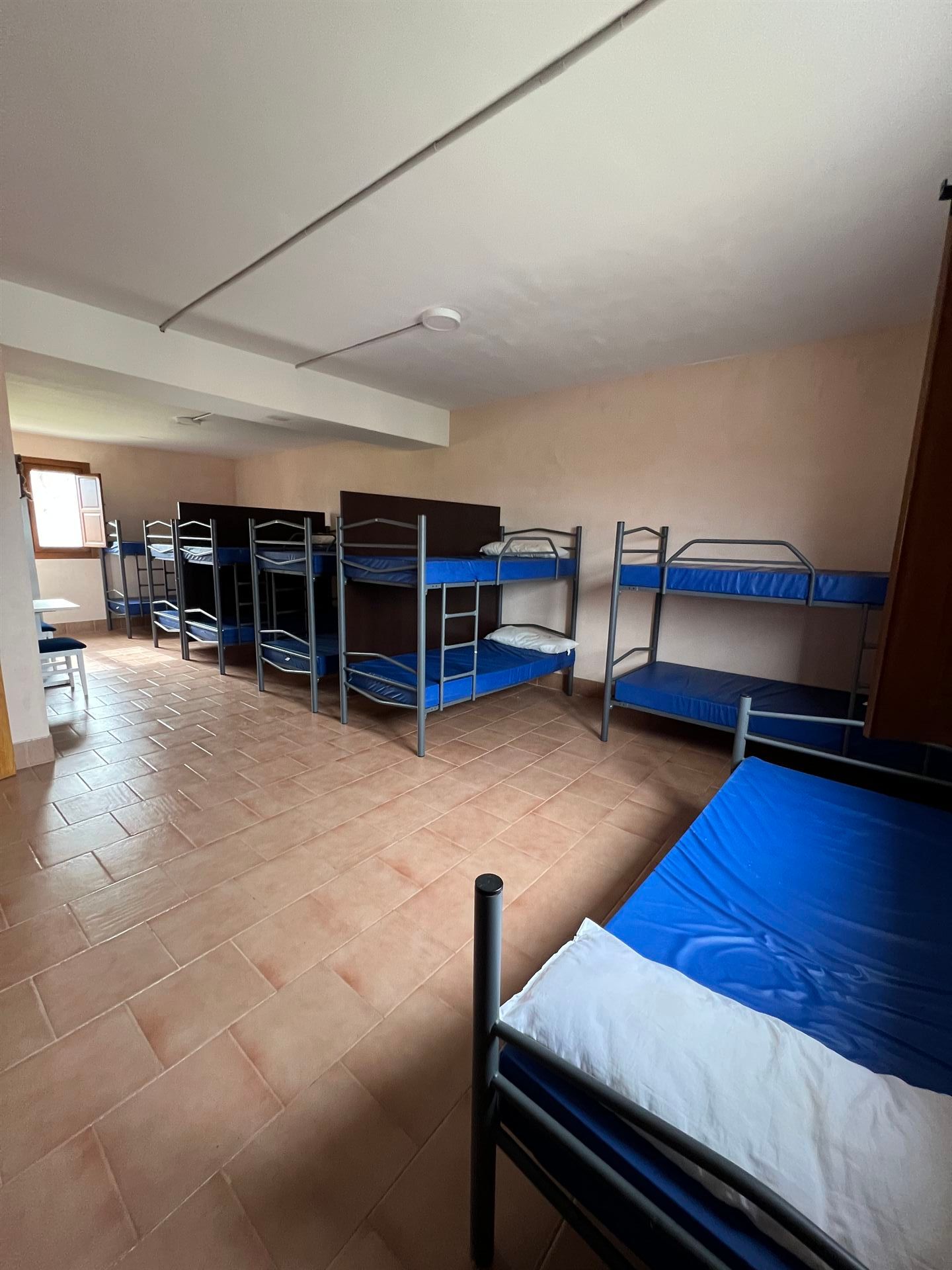 Una habitación llena de literas y una ventana.