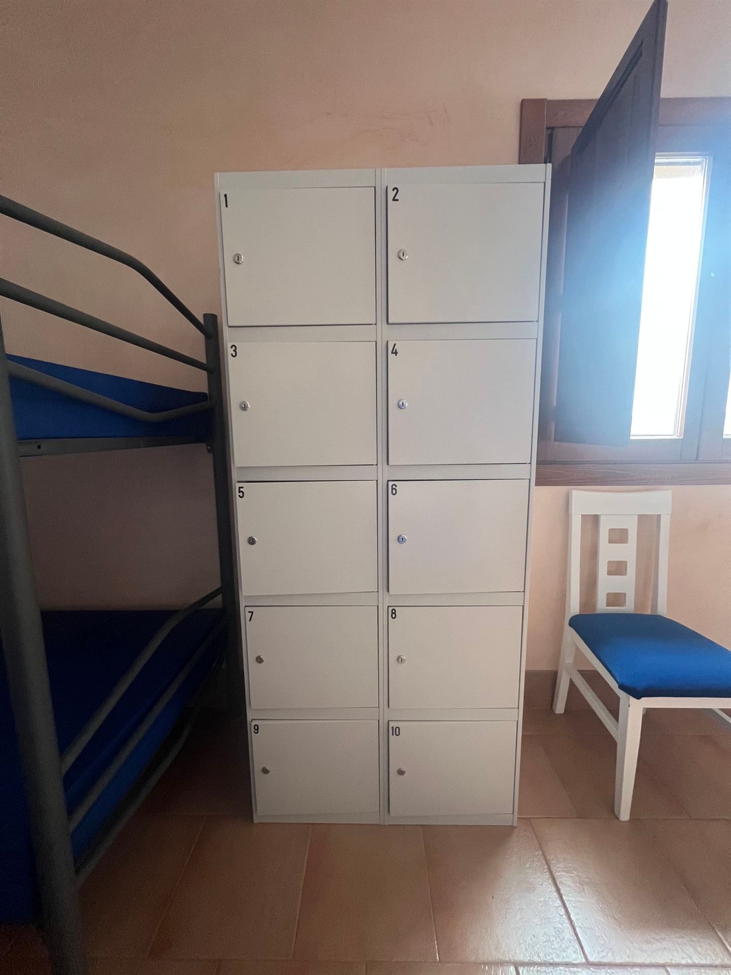 Una habitación con literas y un locker con el número 12.