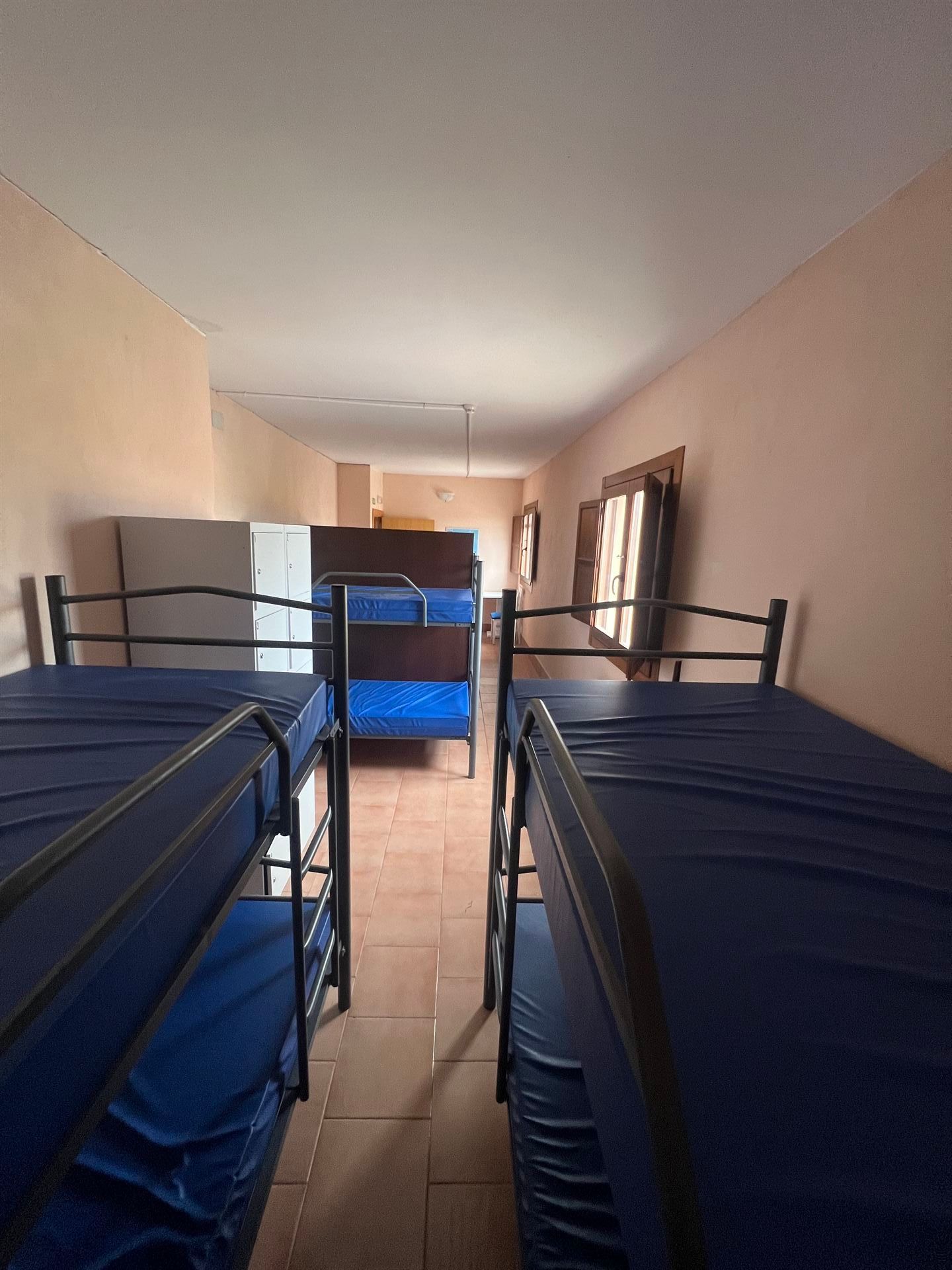 Una habitación llena de literas con colchones azules