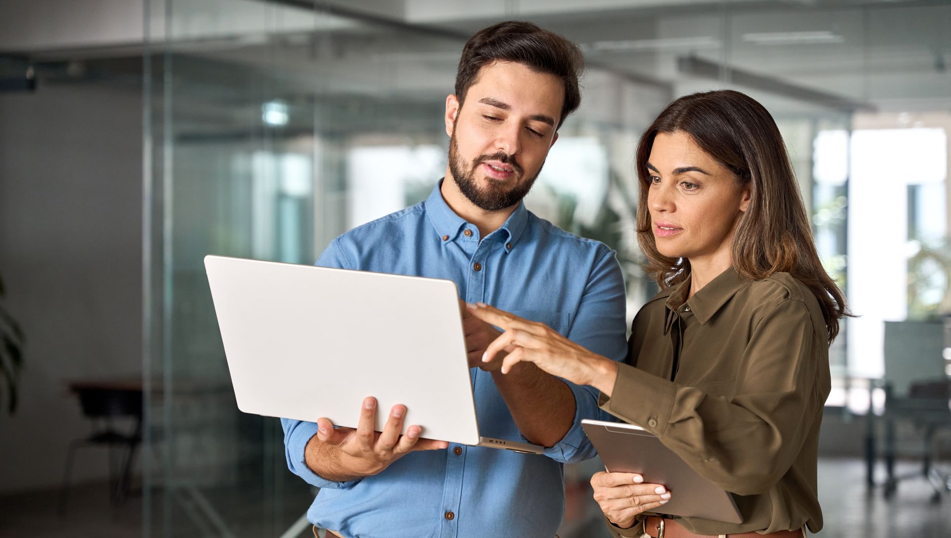 A man and a woman are looking at a laptop computer.