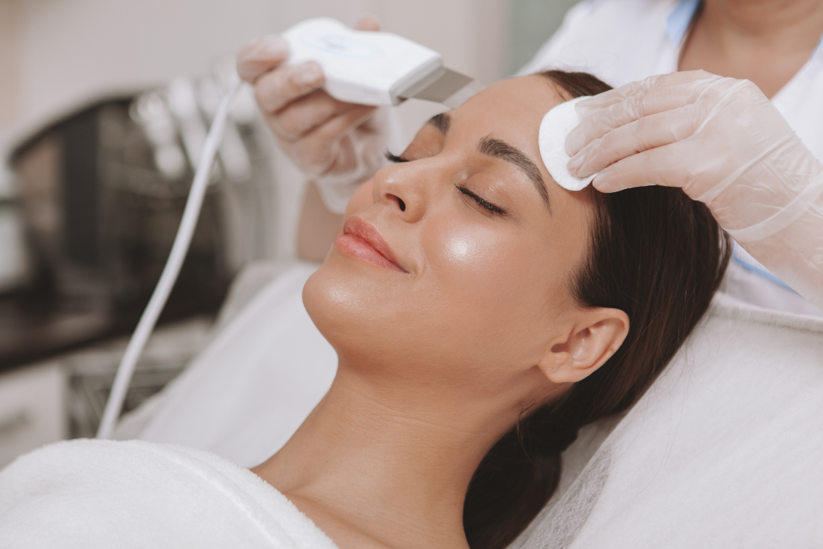 Spa treatment with a woman receiving a facial massage and skincare treatment while lying down