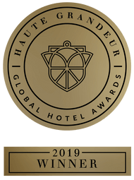 Gold seal: Haute Grandeur Global Hotel Awards 2019 Winner. Circular emblem with a geometric design.