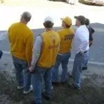 A group of people are standing next to each other on the side of the road.