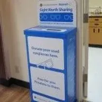 A blue donation box is sitting next to a door in a room.