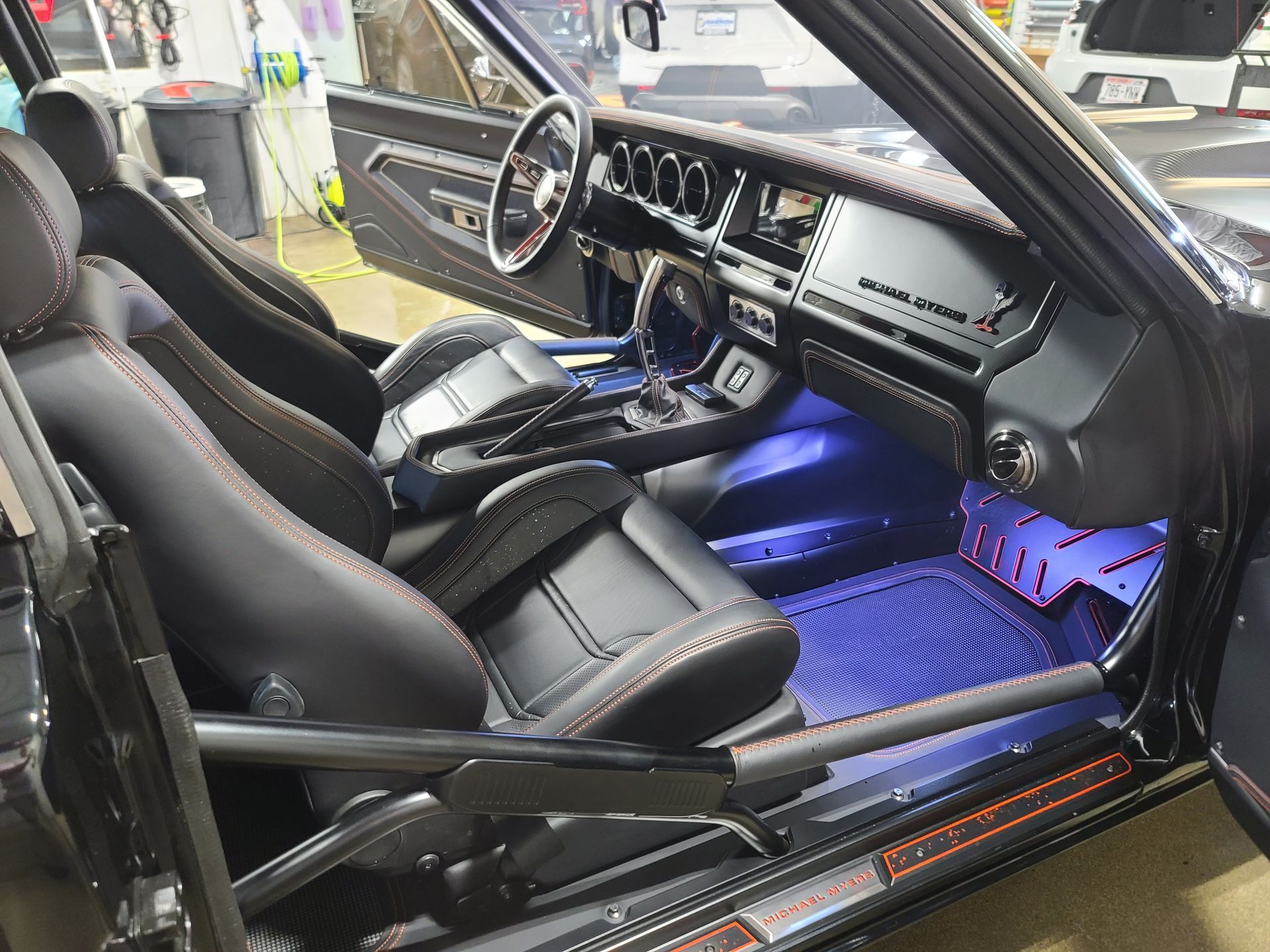 Black car interior with red stitching. Blue underglow, custom dash, and racing seats.