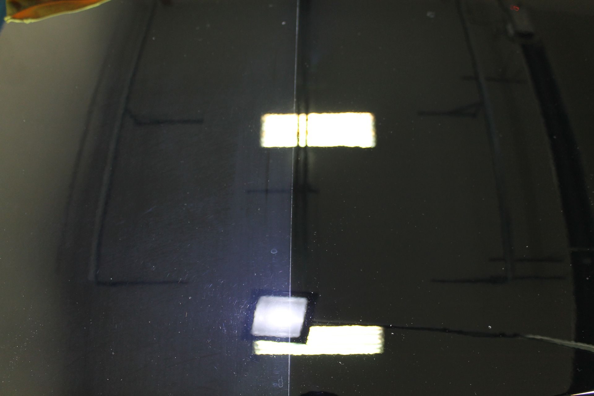 Comparison of a car hood, left side dull, right side glossy after detailing.