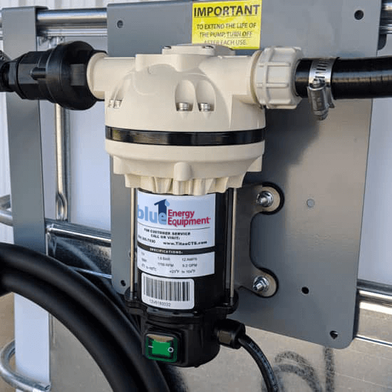 White inline water filter mounted on a gray panel with black hoses and a yellow “IMPORTANT” label.