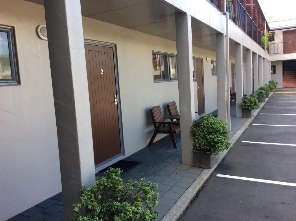 A motel with a row of rooms and a parking lot
