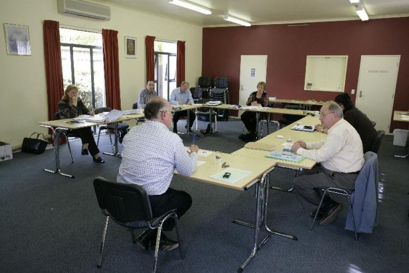 A group of people are sitting around tables in a room