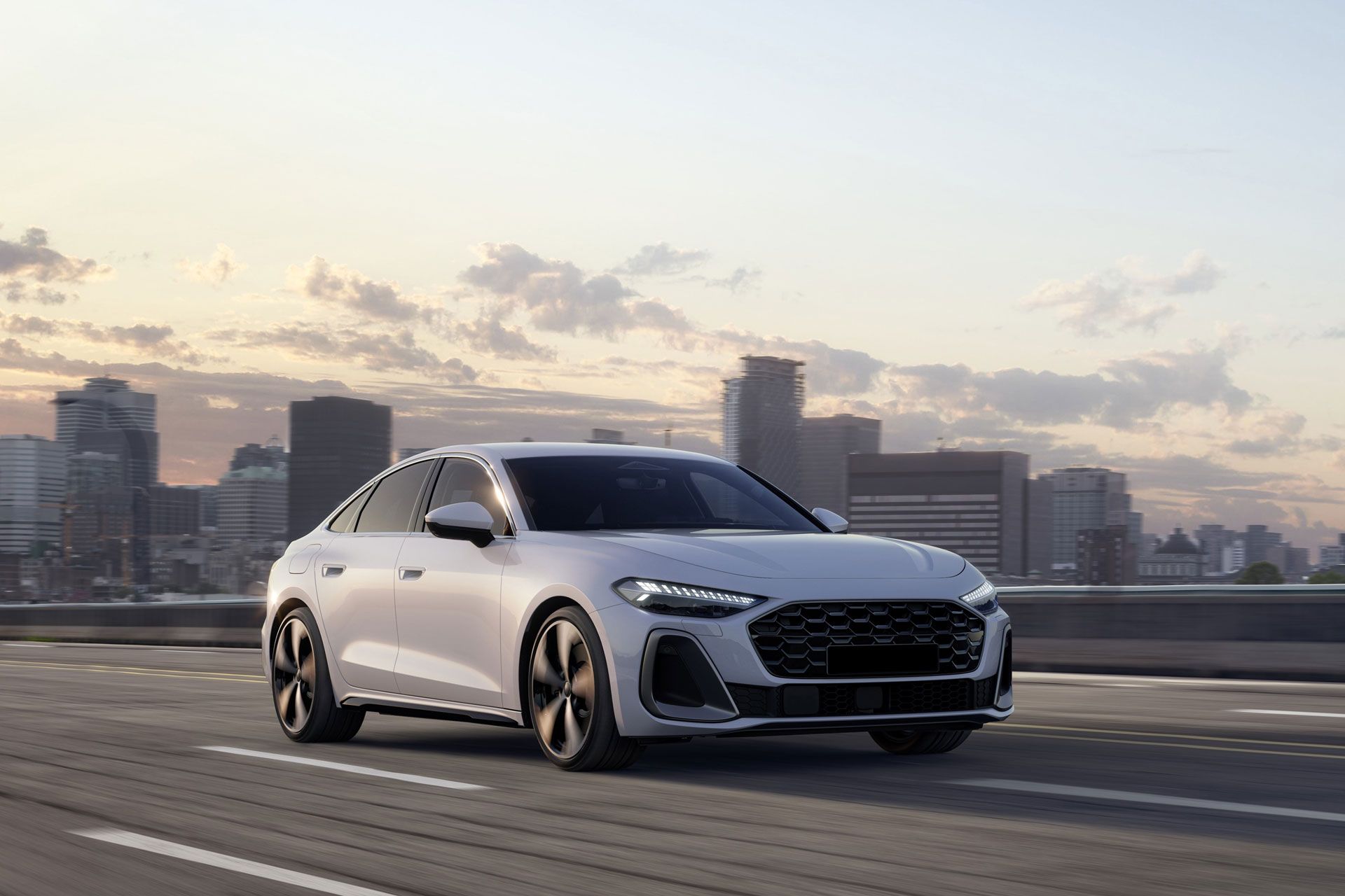 White Audi sedan driving on a road, city skyline in the background.