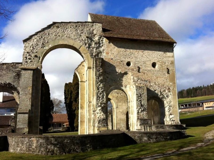 Ancient stone archway ruin with arched openings under a blue sky