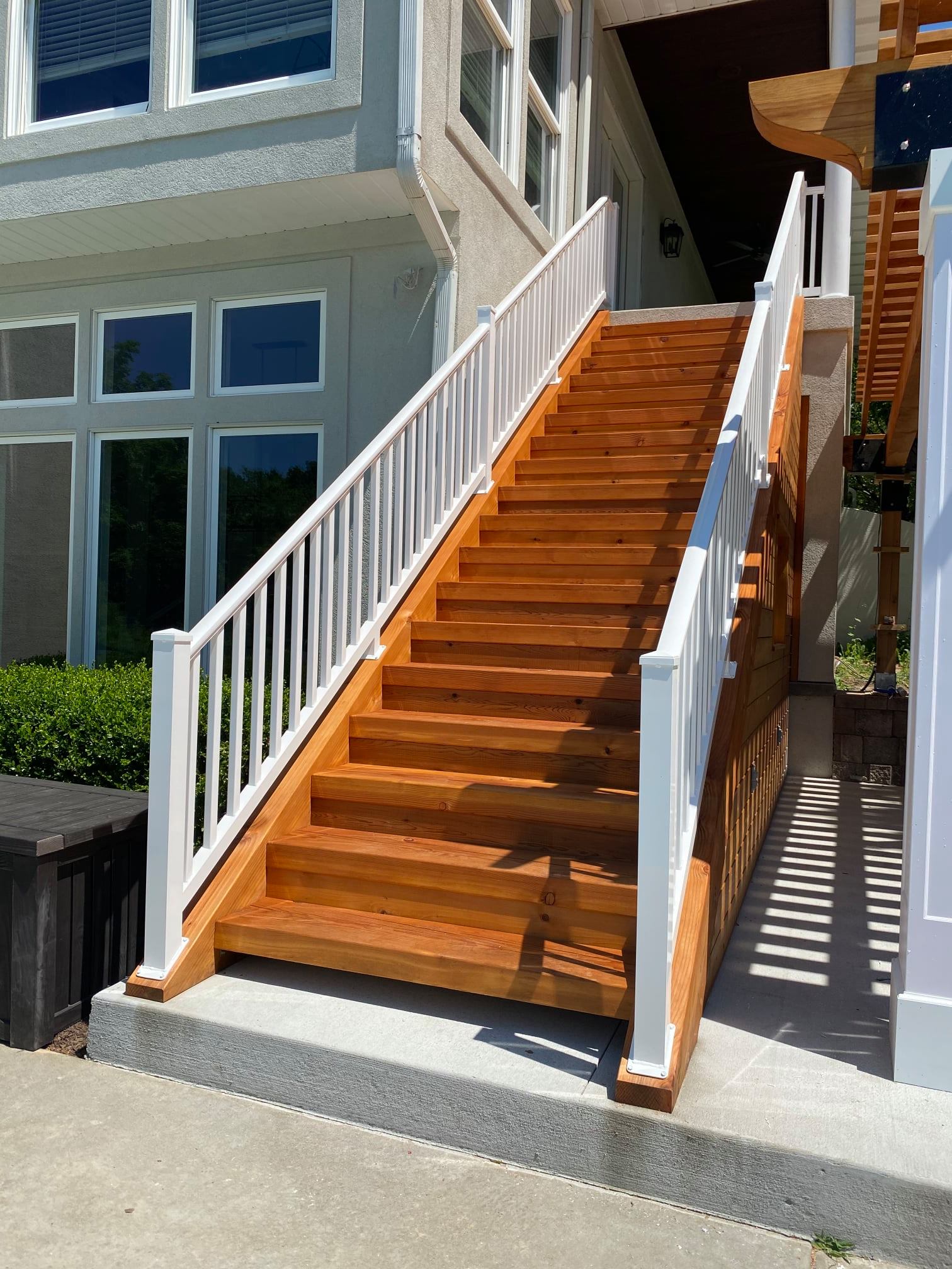 Outdoor wooden staircase with white railings leading up to a building entrance