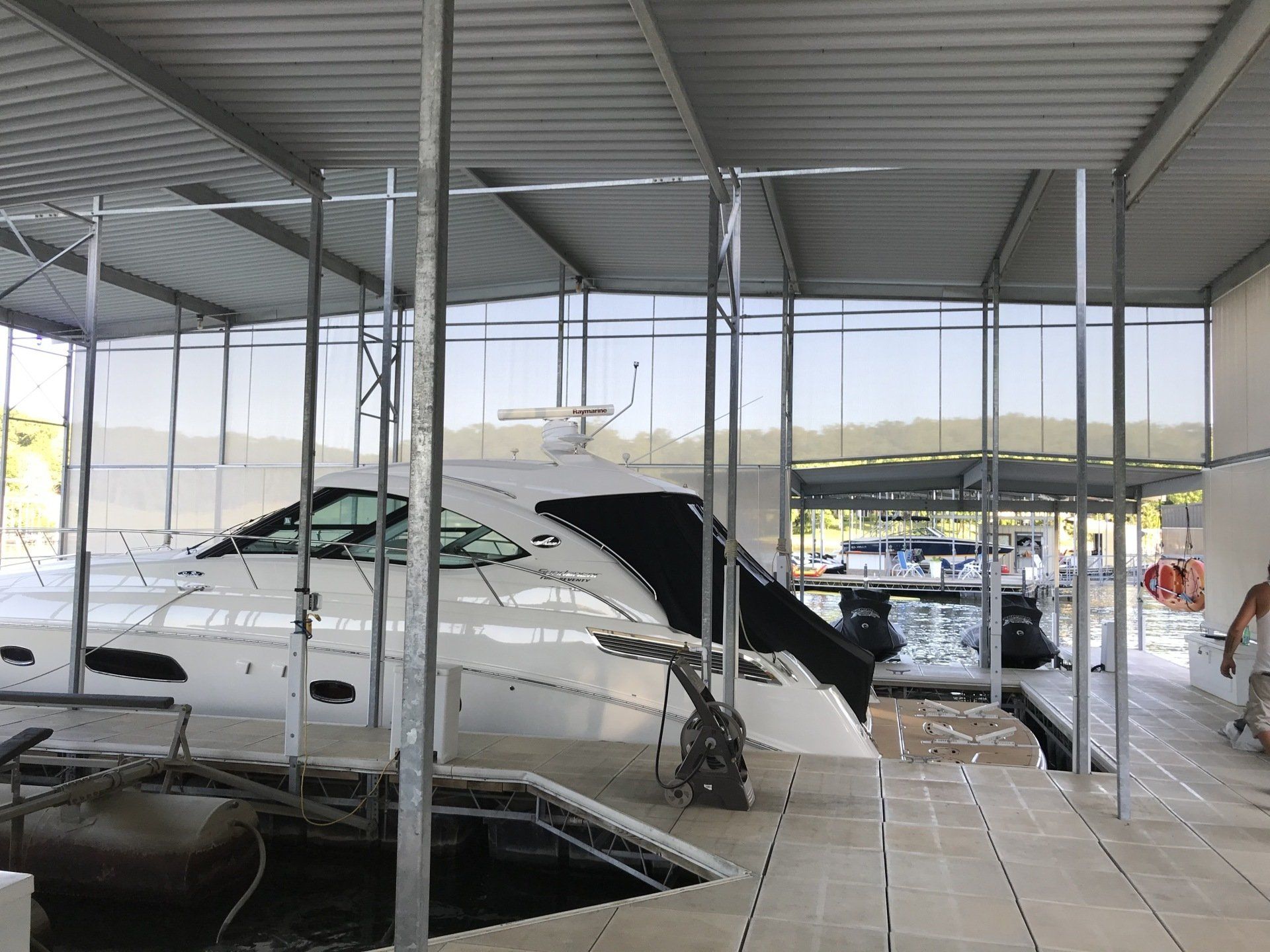 Covered auto storage lot with damaged white cars parked under a metal roof