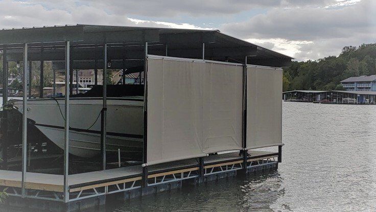 Covered dock or floating platform on calm water under a cloudy sky.