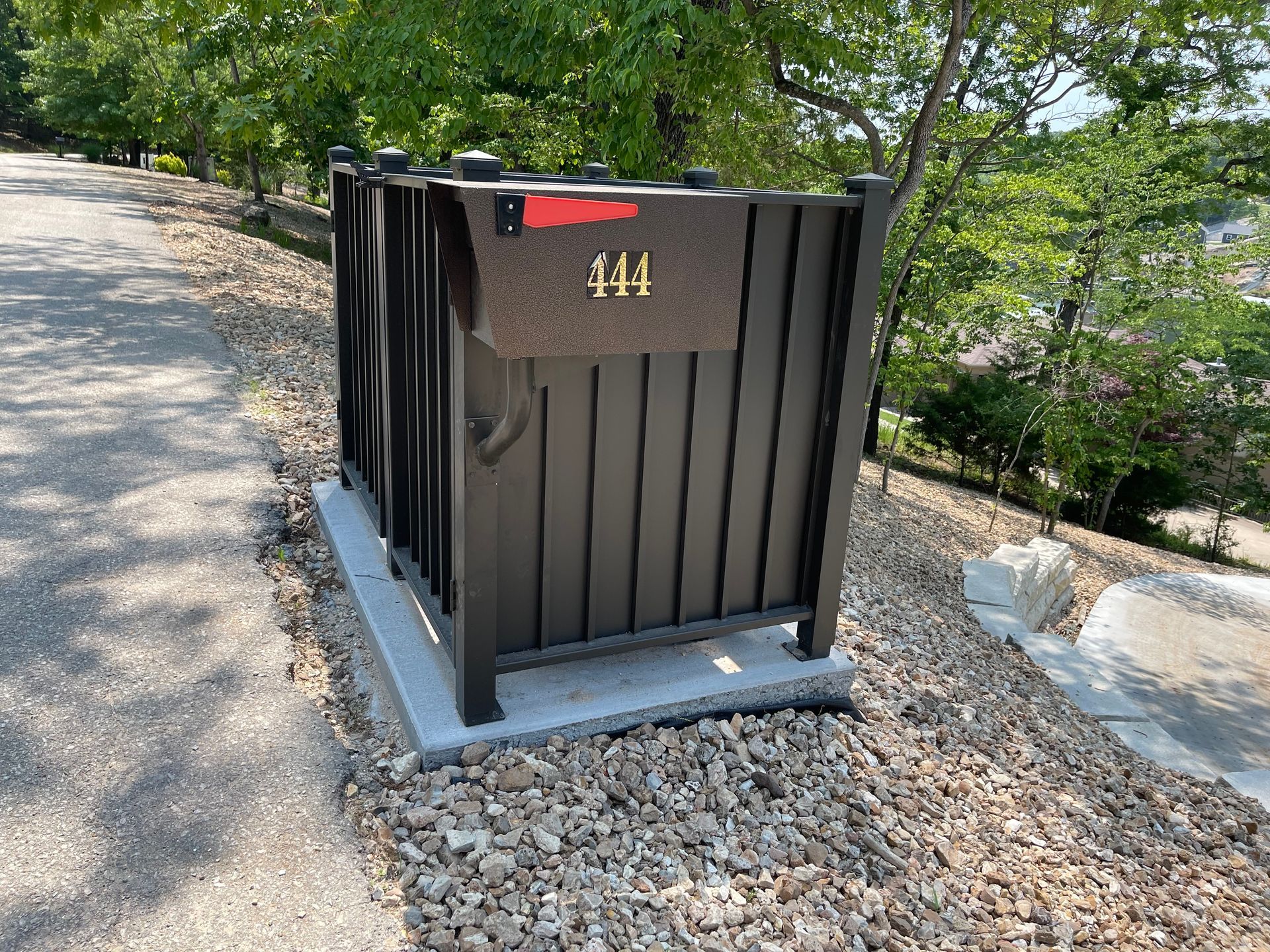 Black utility box marked “414” beside a gravel path and greenery.