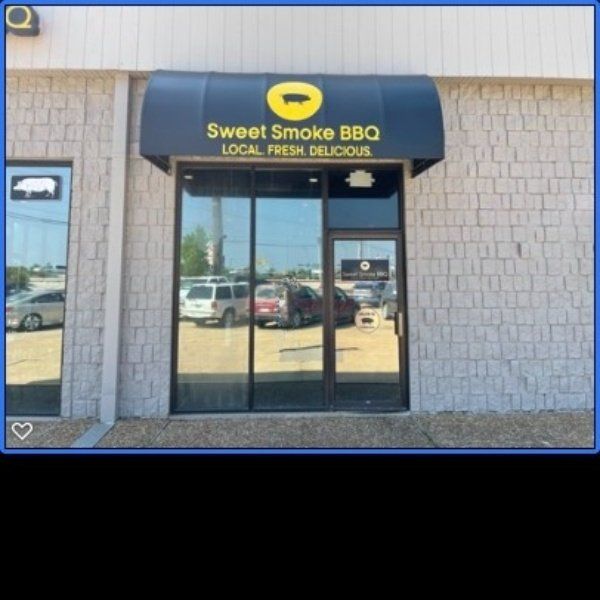 Sweet Smoke BBQ storefront with black awning and glass door in a strip mall