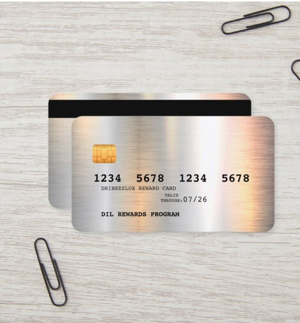 Silver credit card with black card behind on light wood desk, with paper clips nearby