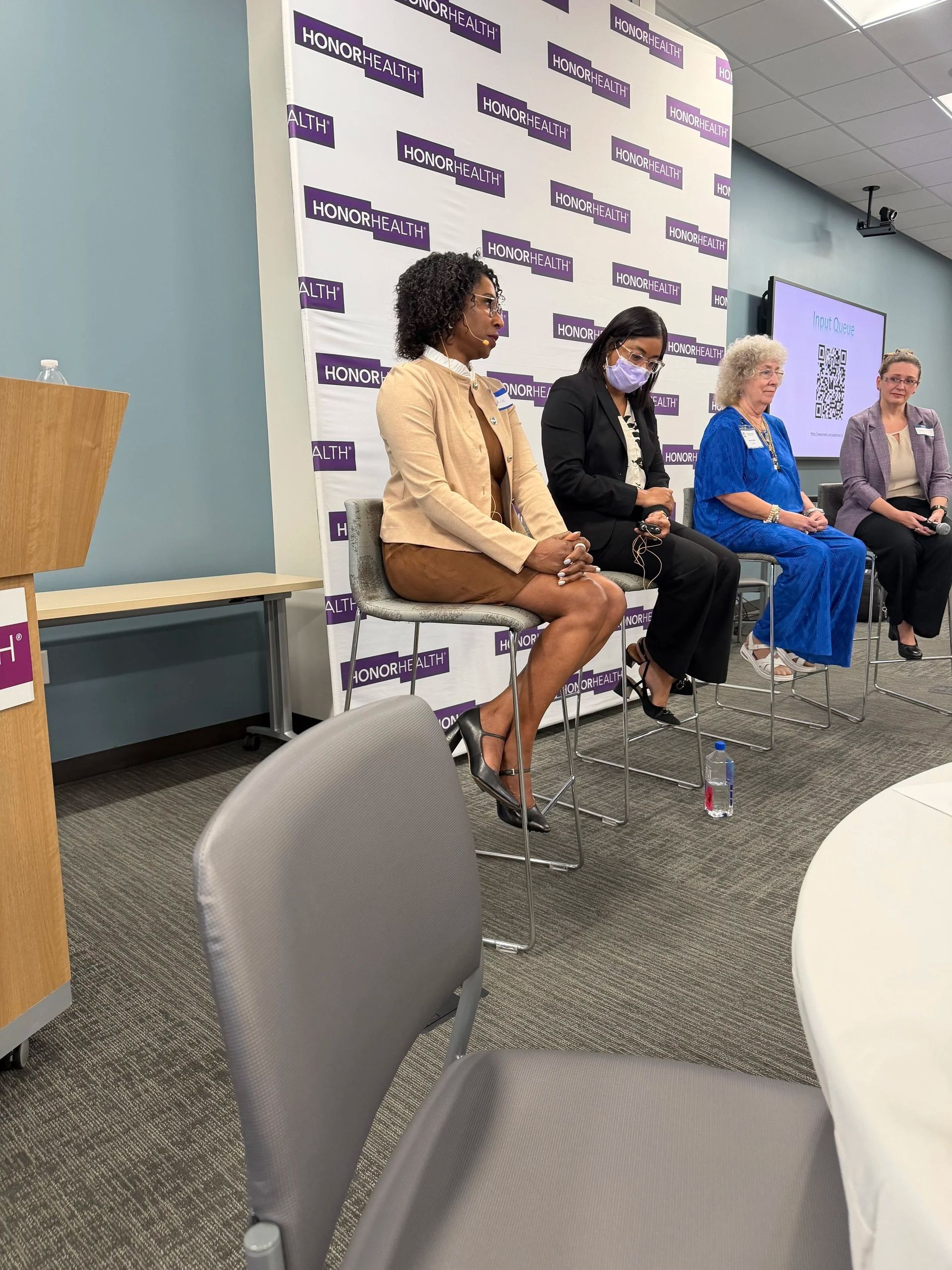 Panel discussion with four speakers seated on a stage at a conference