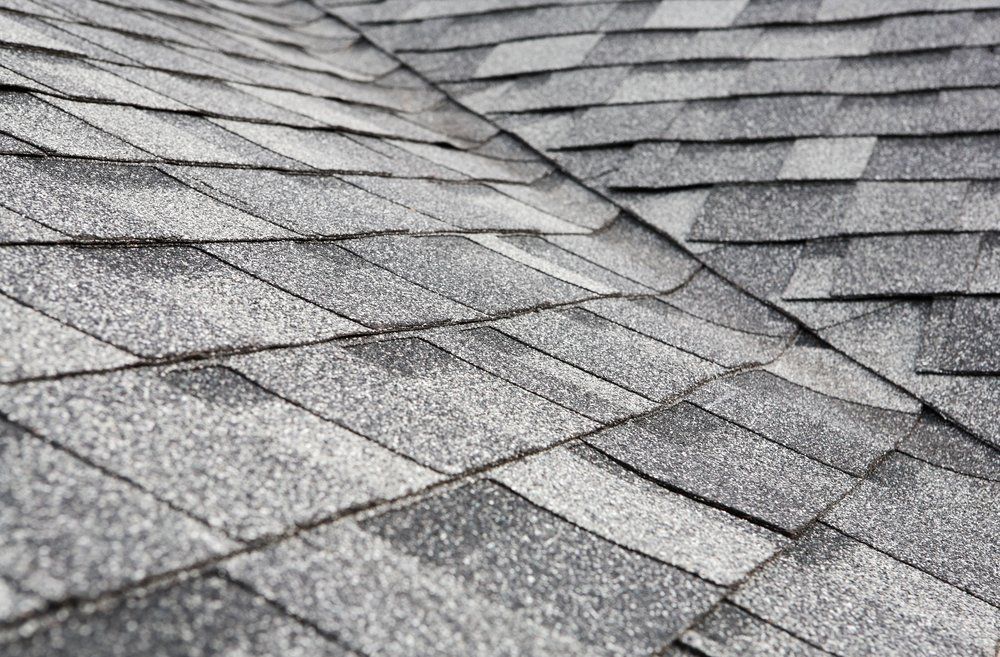 Close-up of gray asphalt roof shingles with a textured, overlapping pattern
