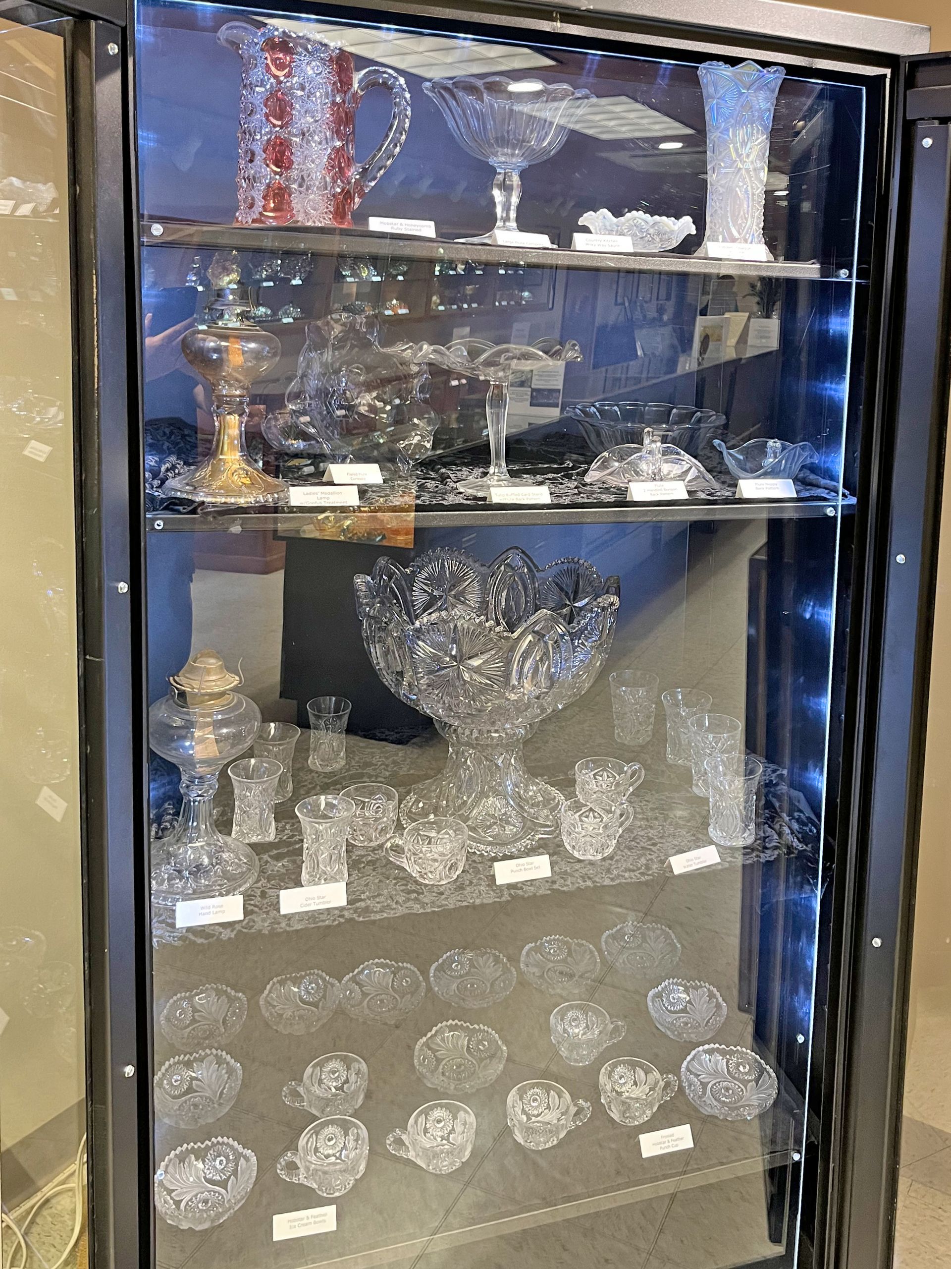 Glassware display cabinet with various crystal pieces on shelves.
