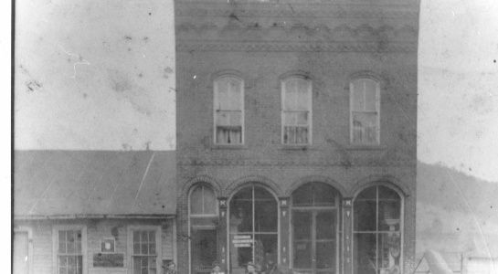 Two-story brick building with arched windows on the first floor and arched top windows above.