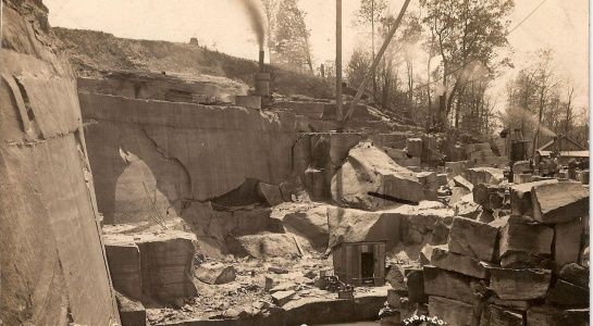 Stone quarry with large blocks, steam rising, and a rudimentary archway.