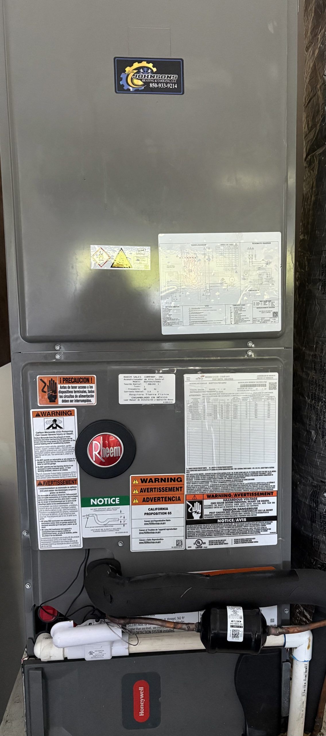 Gray industrial cabinet with posted notices and labels above a workbench with tools and supplies