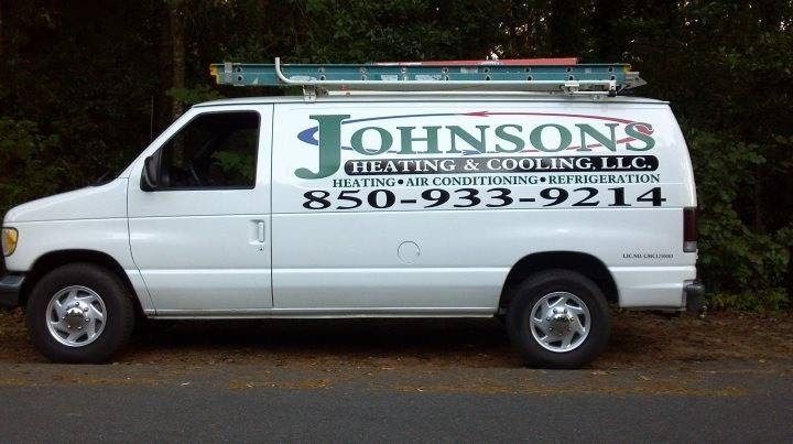 White Johnson’s Plumbing van parked outdoors with business logo and phone number displayed on the side
