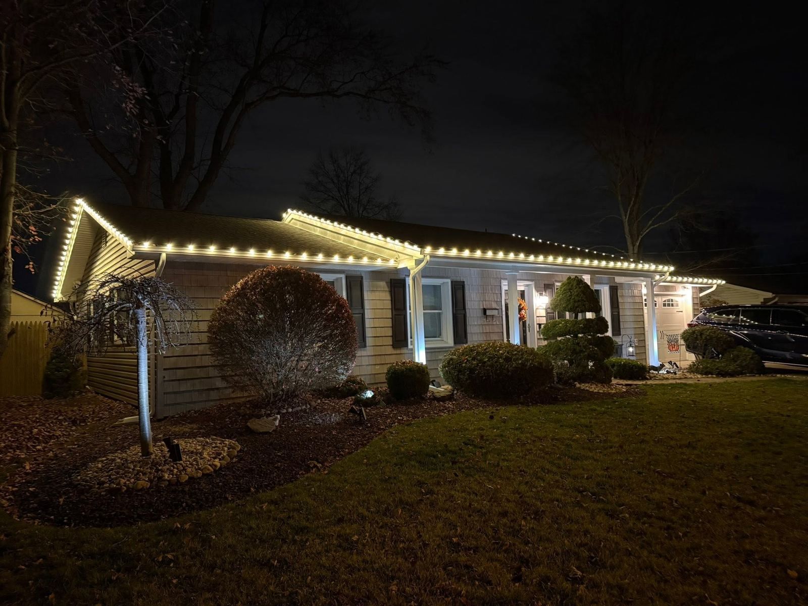 Ranch with roofline Christmas lights at night — Catanzaro's Power Washing