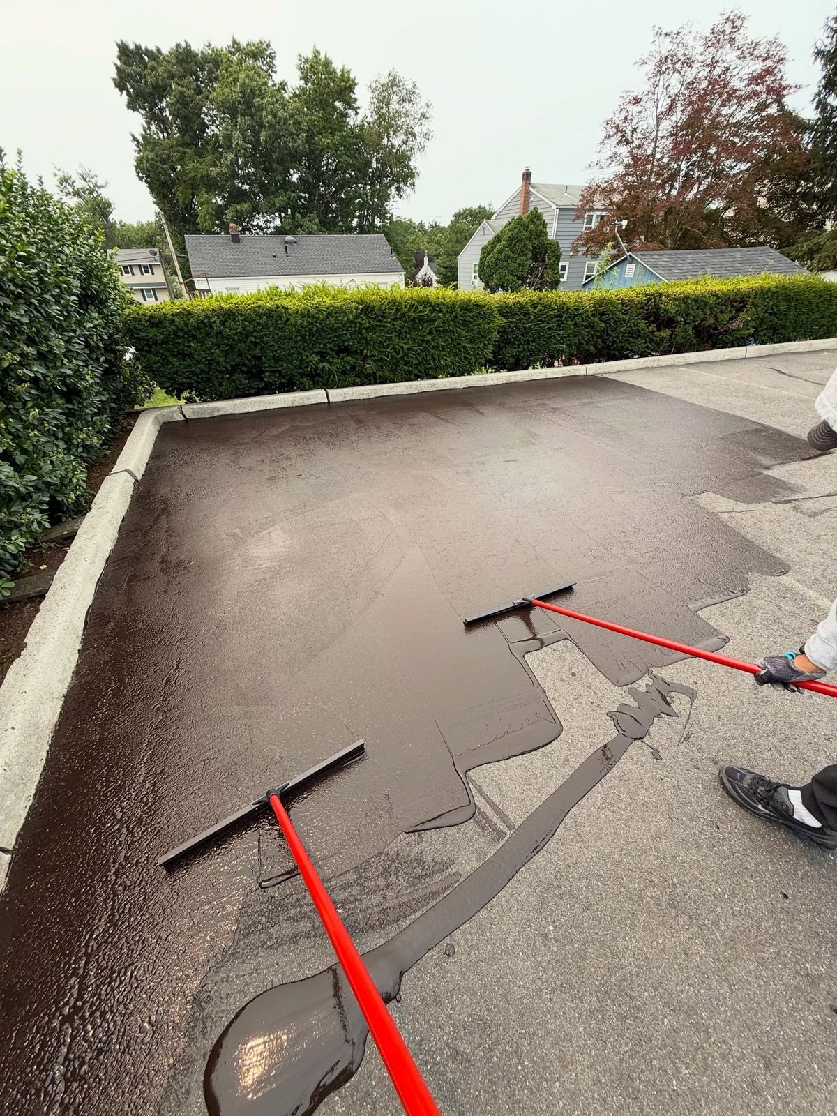 Lot being sealed with squeegees — Catanzaro's Power Washing