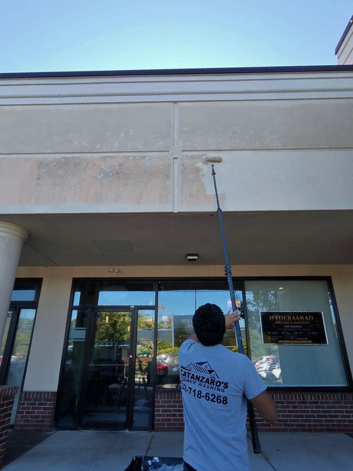Crew washing storefront glass — Catanzaro's Power Washing