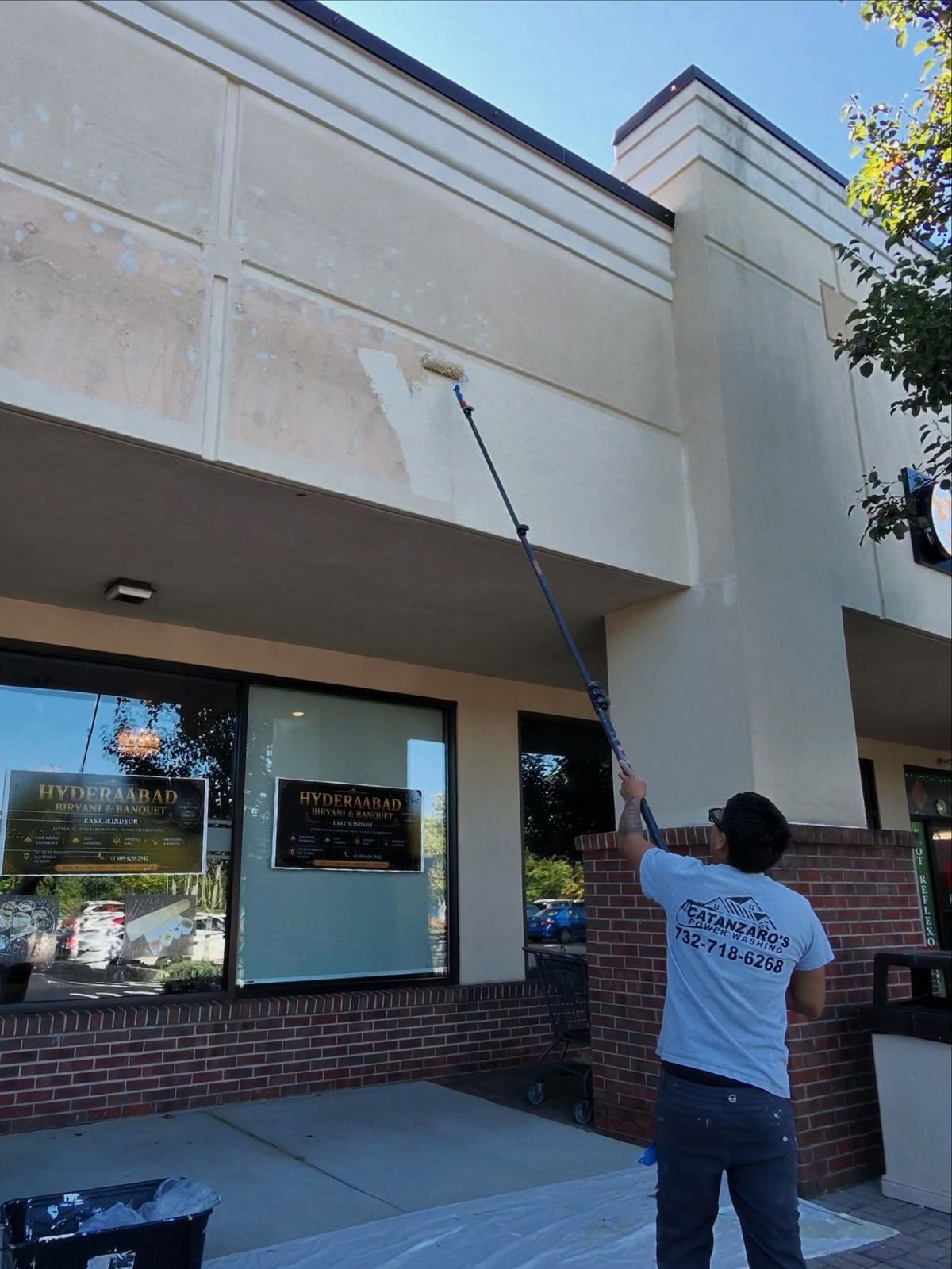Crew washing storefront glass — Catanzaro's Power Washing