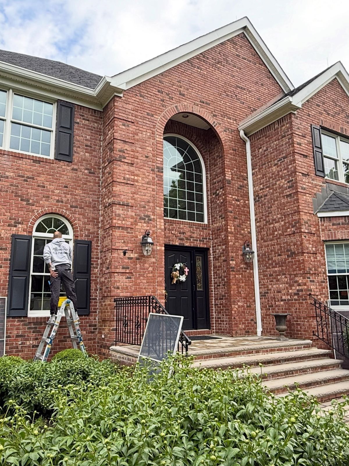 Brick colonial front entry, crew at window — Catanzaro's Power Washing
