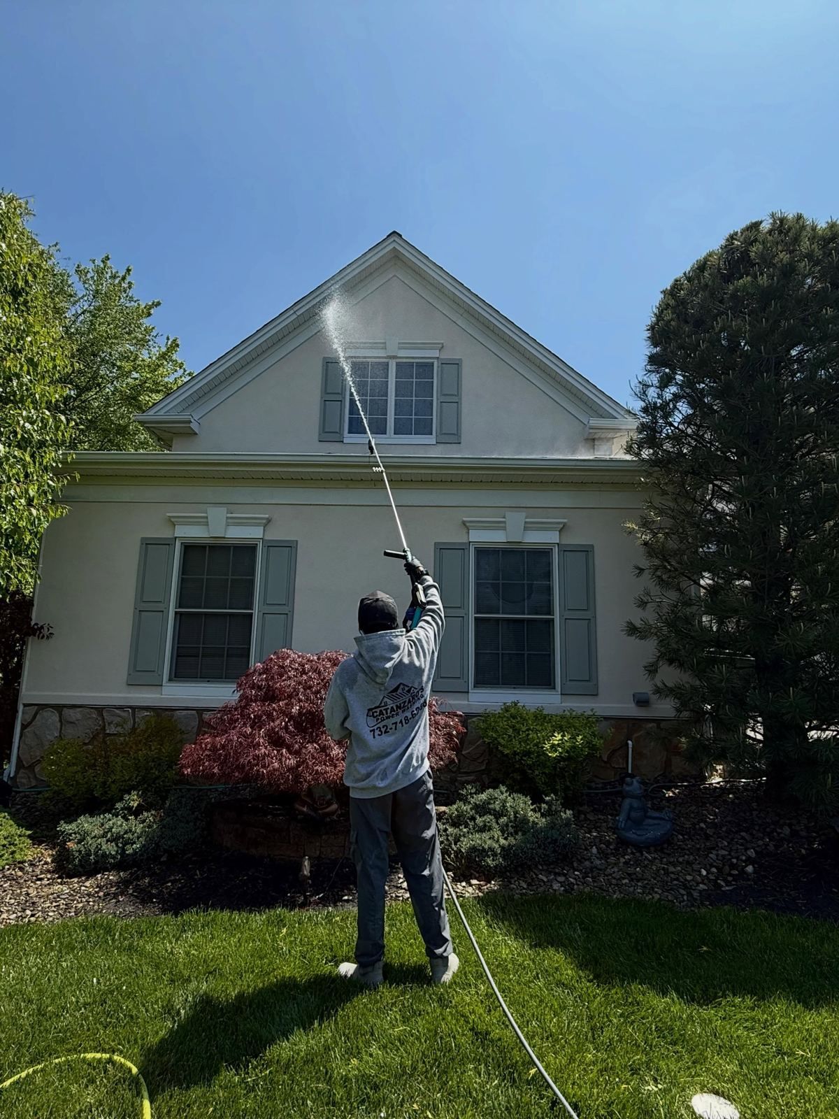 Crew washing cape front with wand — Catanzaro's Power Washing