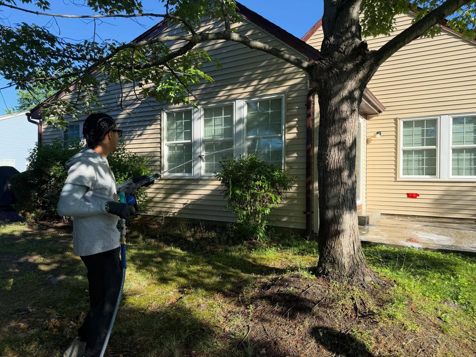 Crew washing tan cape under tree — Catanzaro's Power Washing