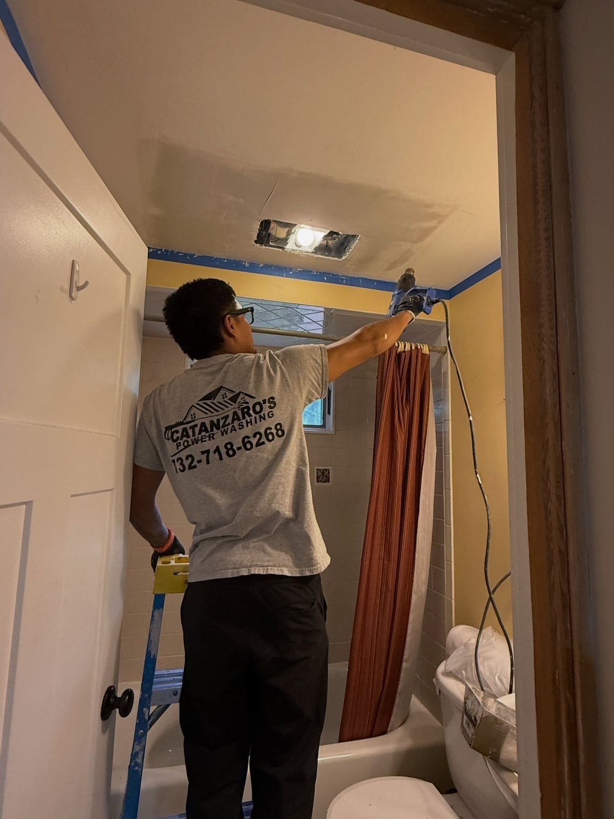 Painter cutting in at bathroom ceiling — Catanzaro's Power Washing