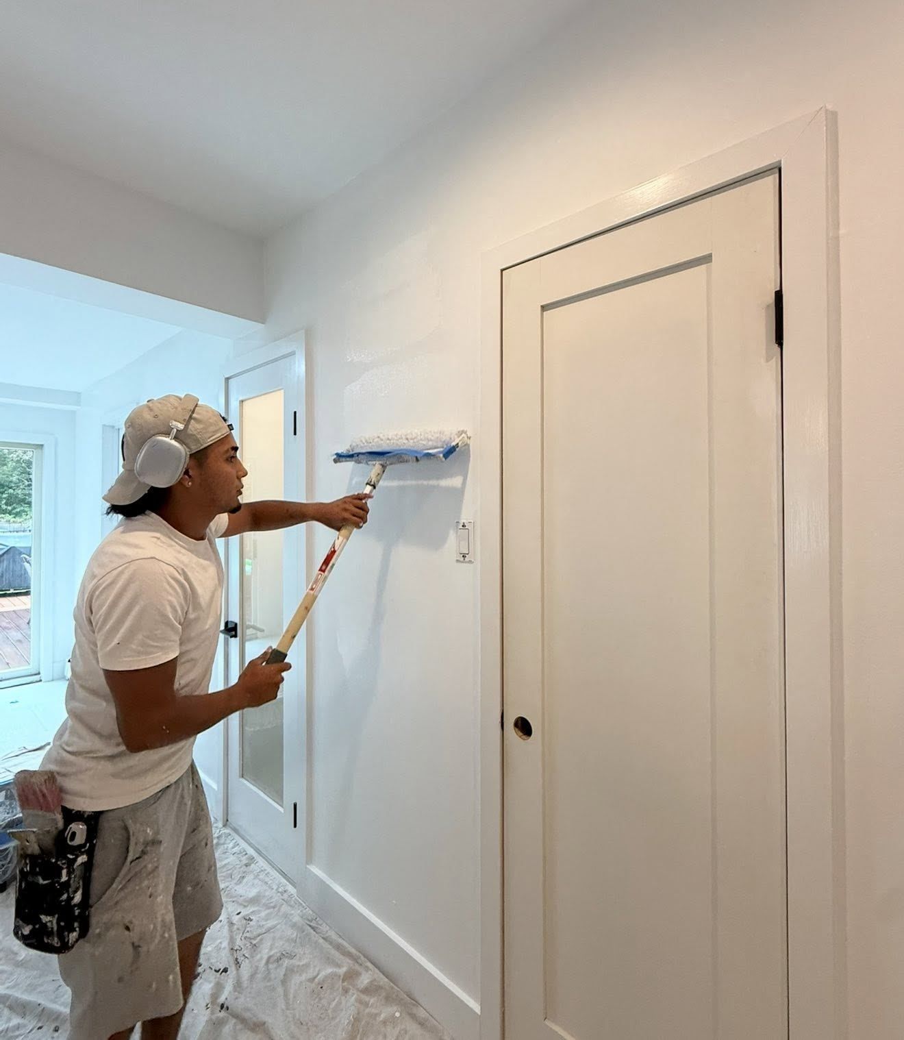 Painter rolling white wall — Catanzaro's Power Washing