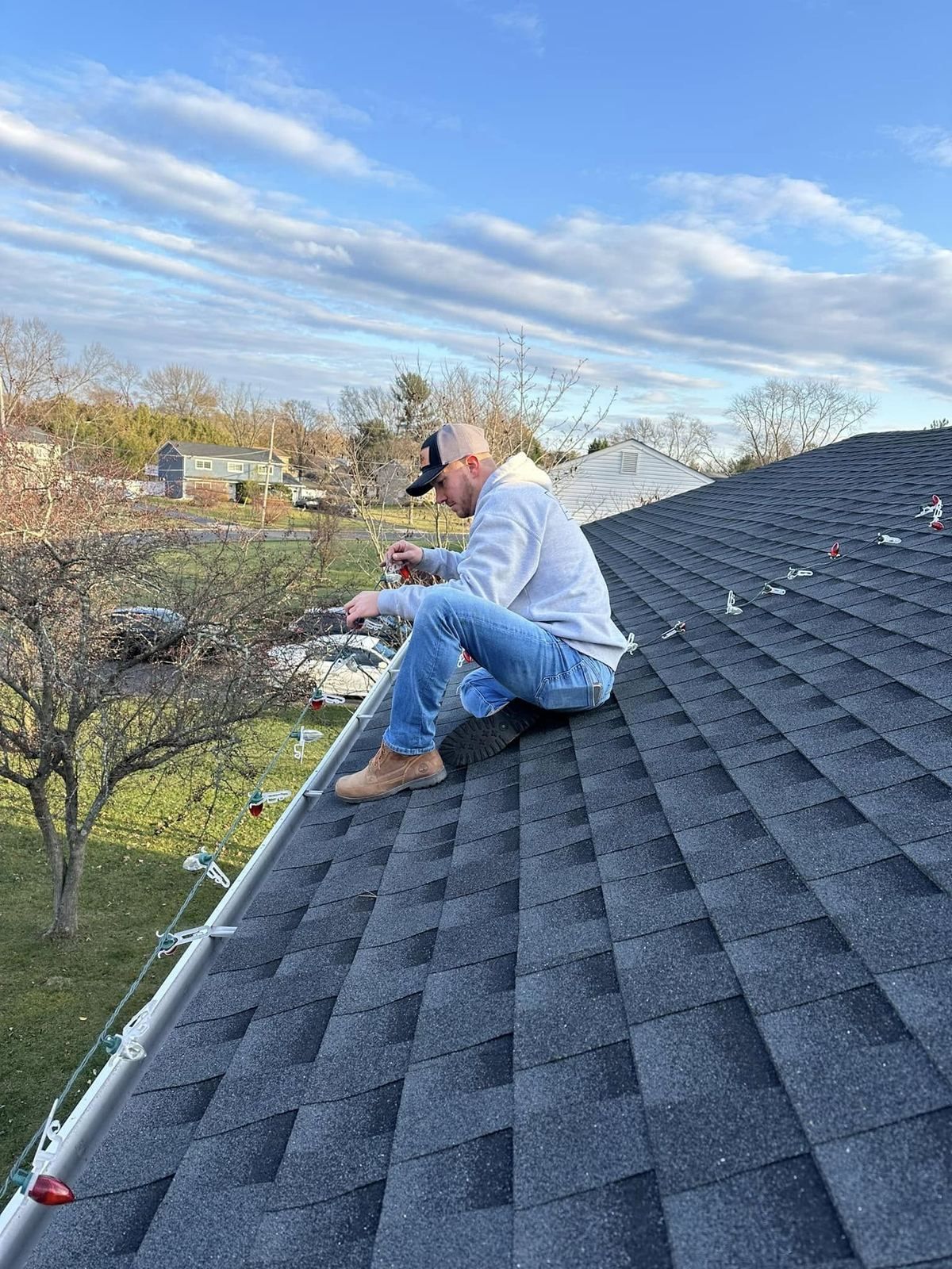 Crew member sitting on shingle roof — Catanzaro's Power Washing