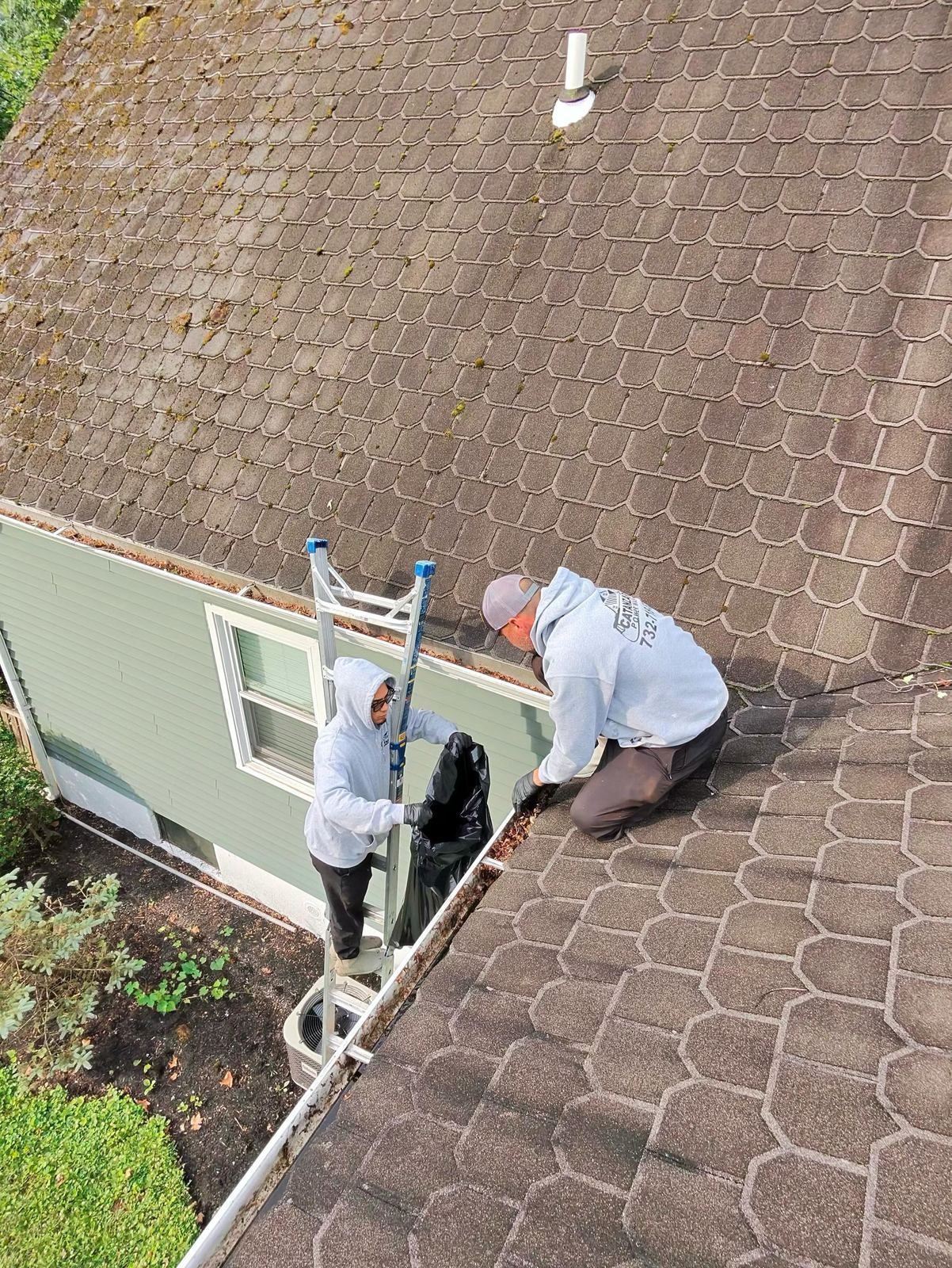 Crew on roof edge with ladder — Catanzaro's Power Washing