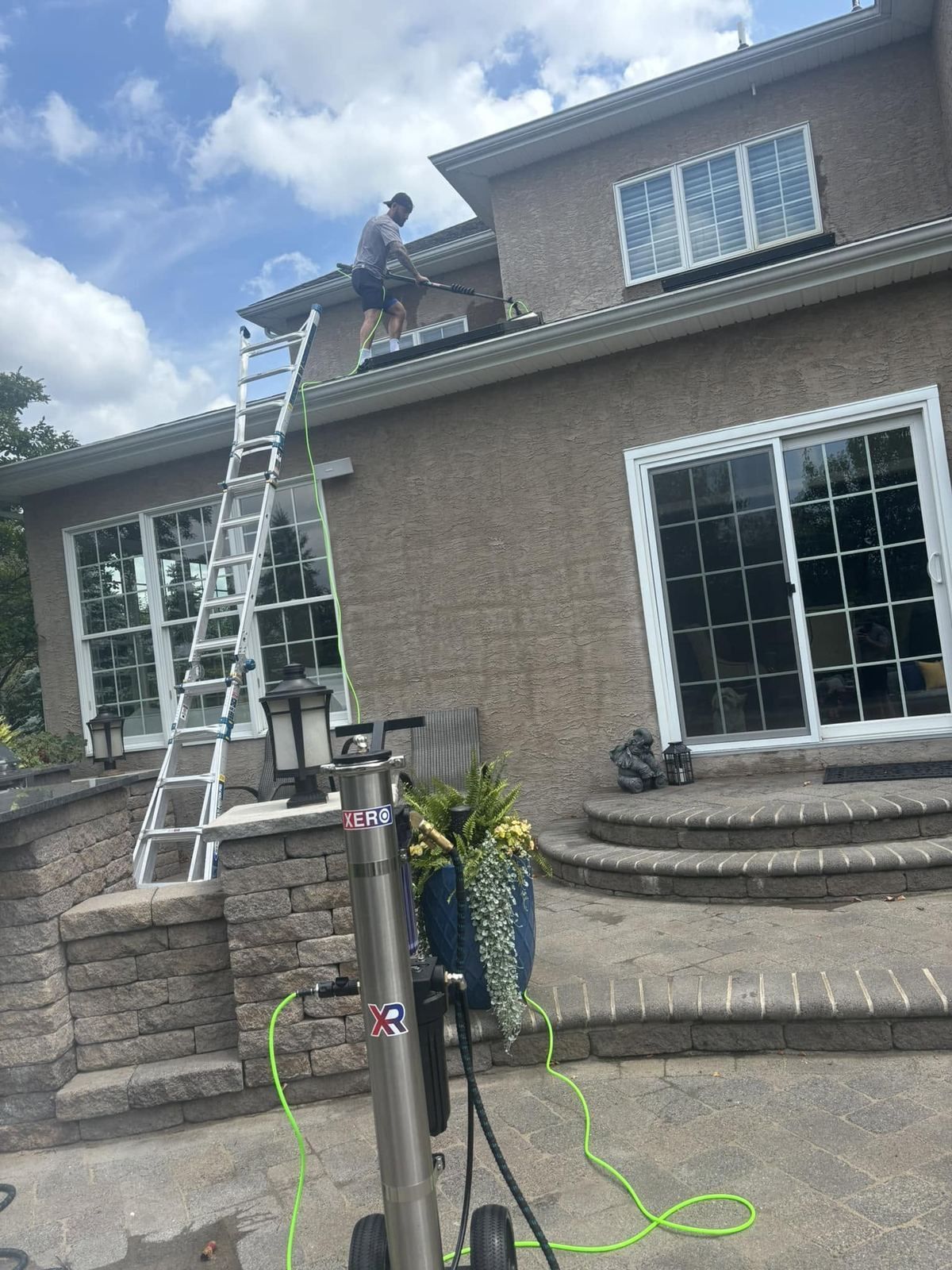 Ladder at second-story window, crew cleaning — Catanzaro's Power Washing