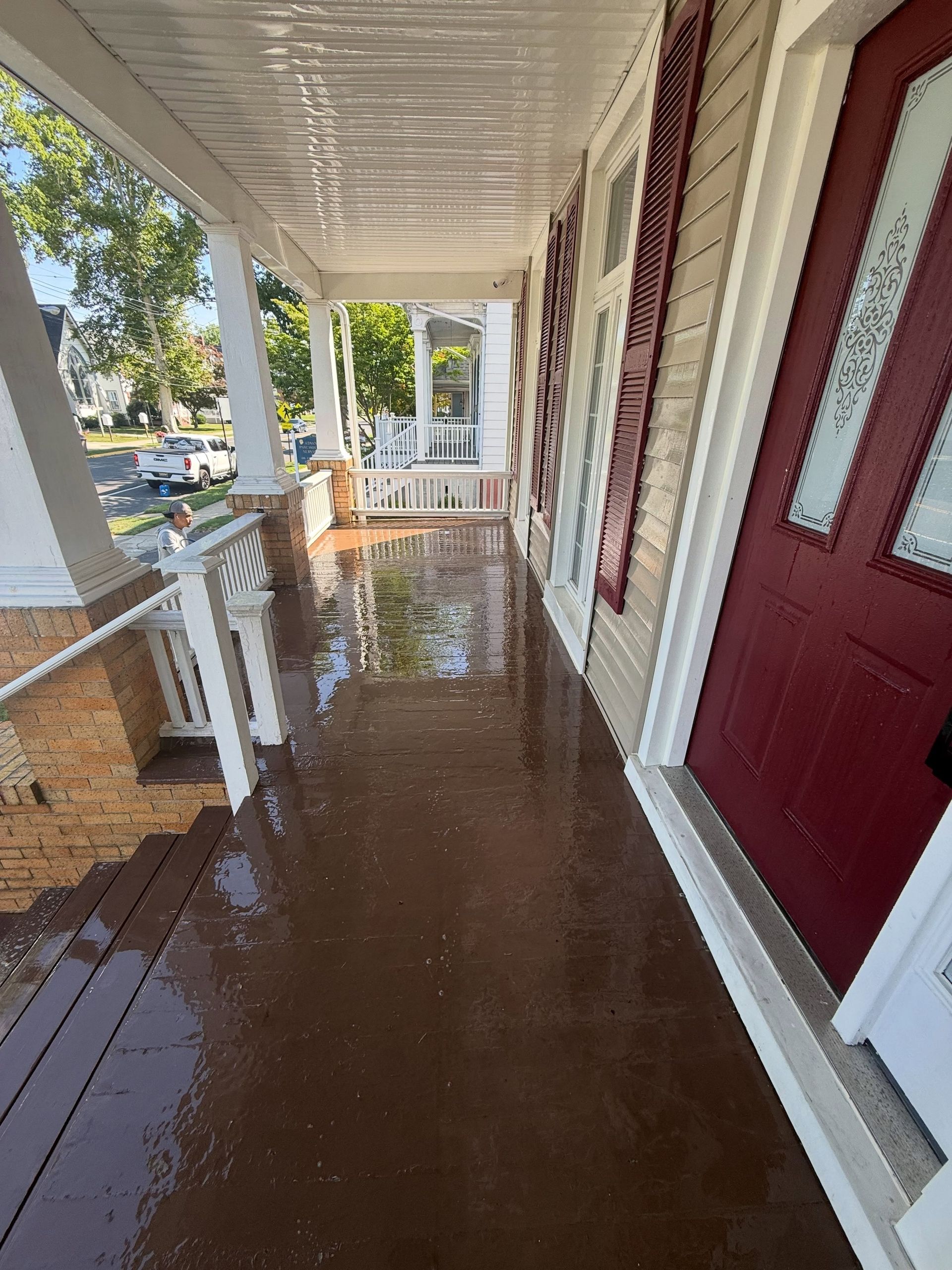 Porch floor stained brown by red door — Catanzaro's Power Washing