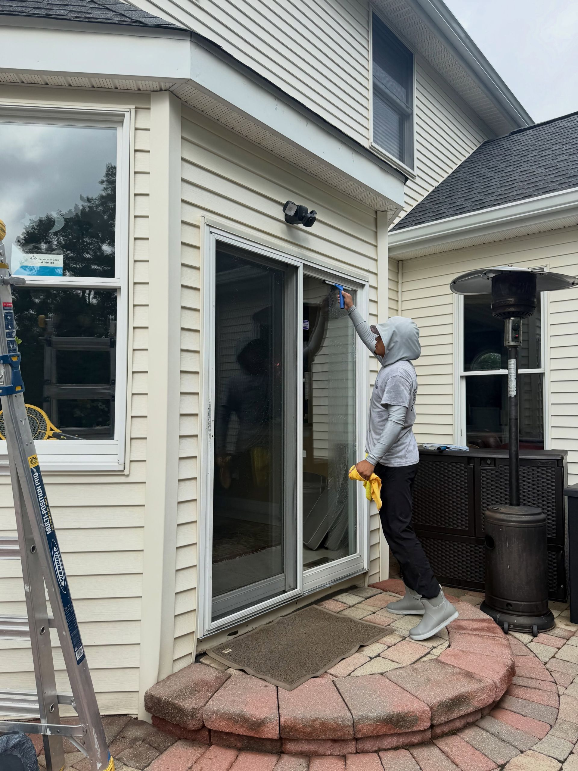 Crew cleaning patio slider glass — Catanzaro's Power Washing