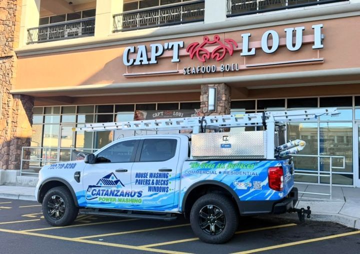 Blue and white utility truck parked in front of a Cap’t Loui restaurant
