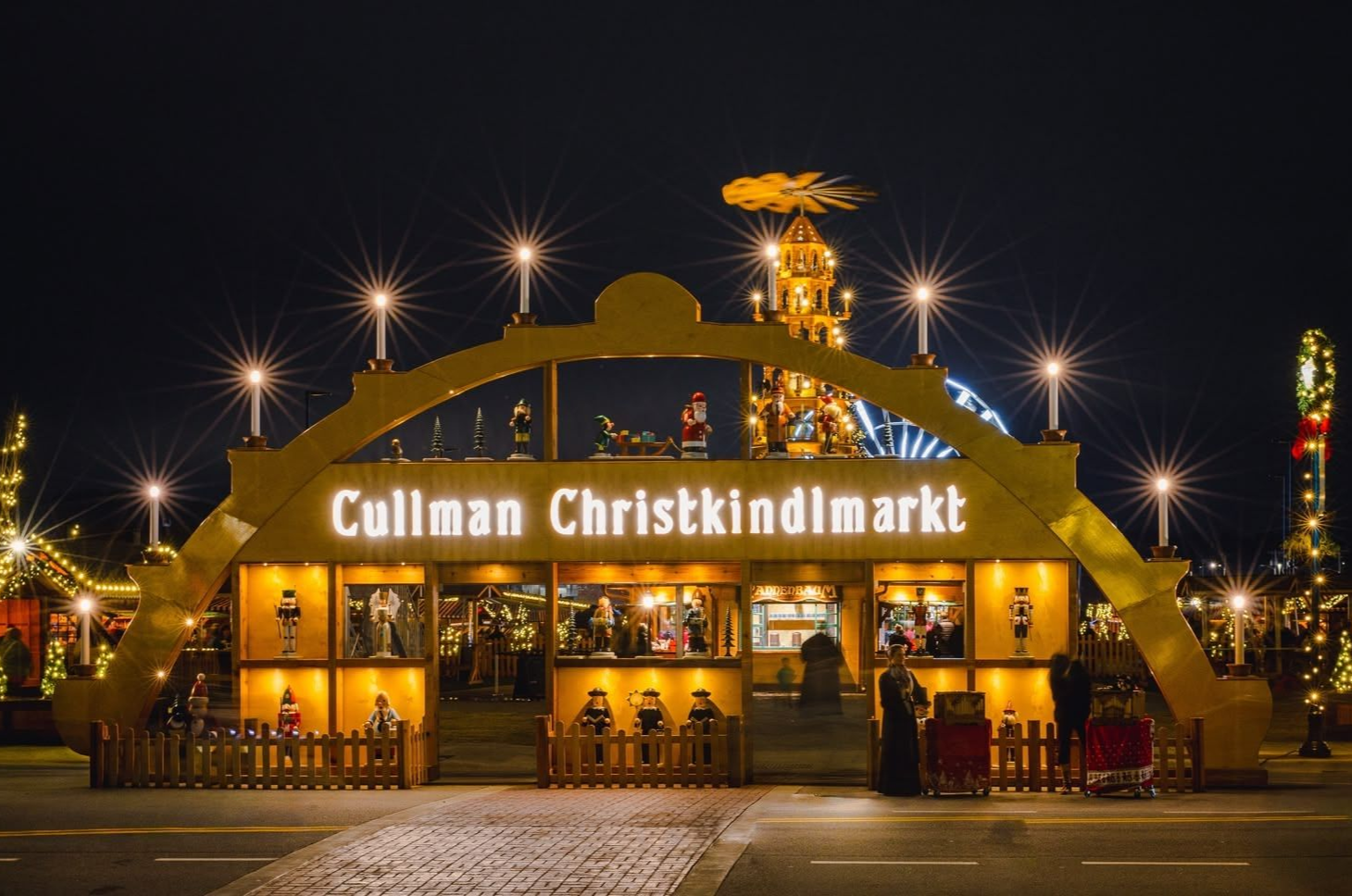 Cullman Christmas market entrance lit up at night, with archway and star decorations