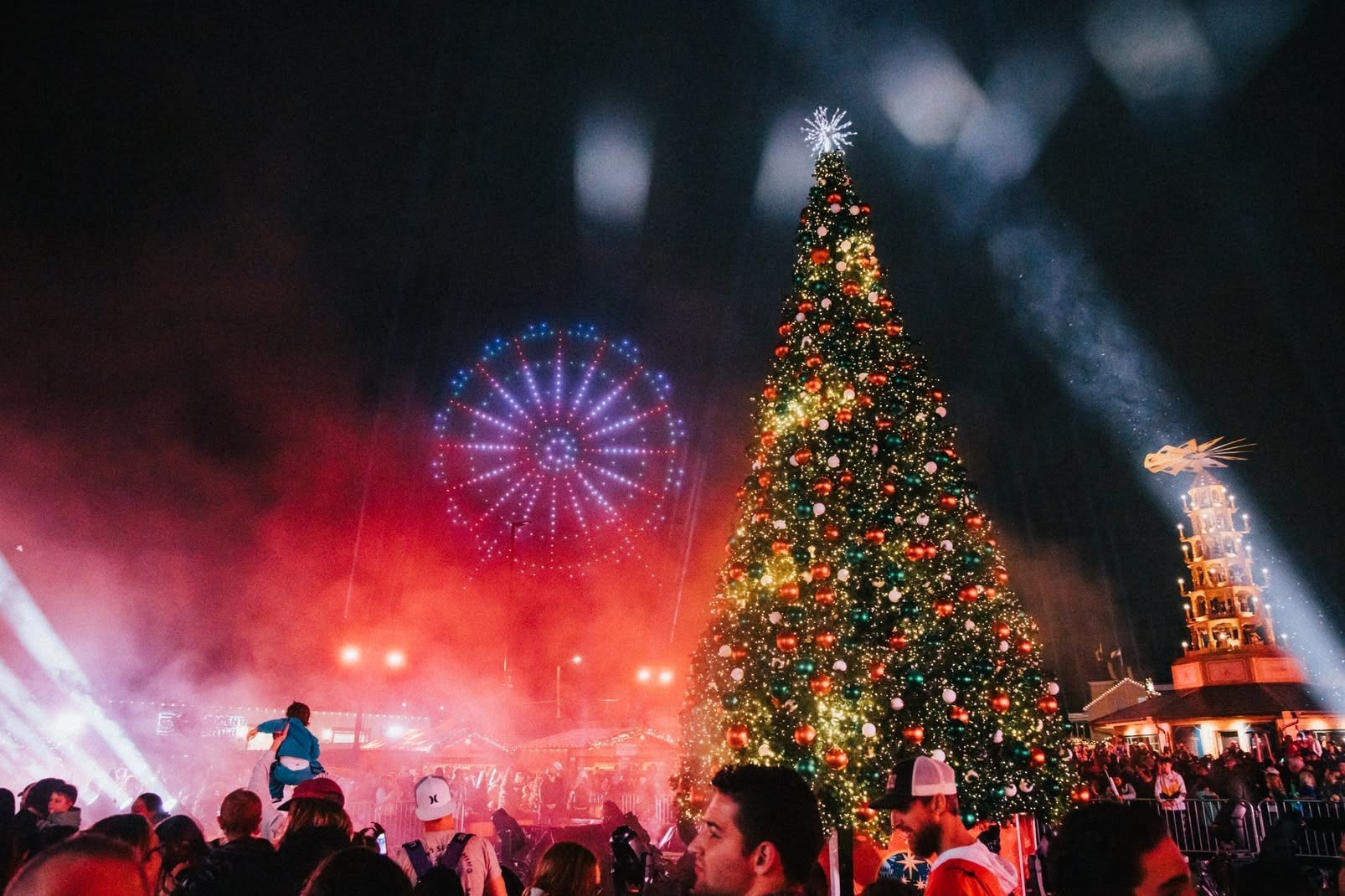A full night at Cullman Christkindlmarkt with a lit Christmas tree, fireworks, and red stage lights