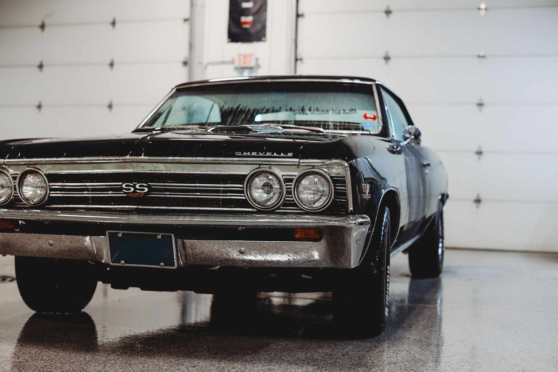 Classic black vintage car parked indoors in a garage, front view