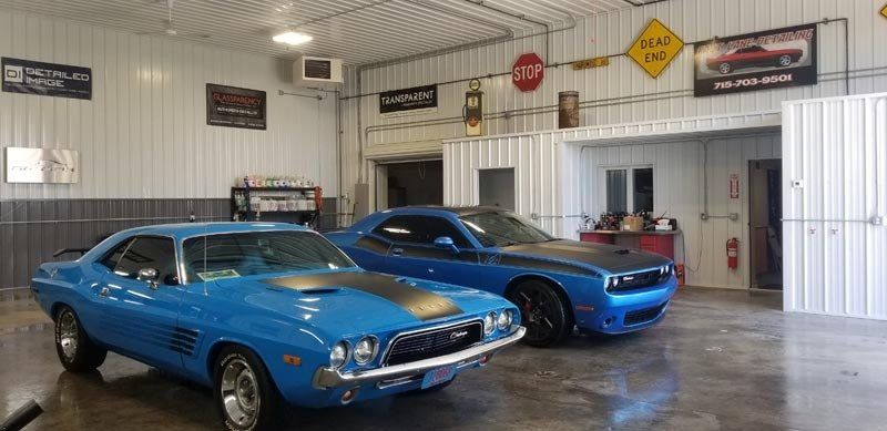 Two blue cars are parked in a garage.