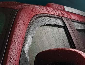A close up of a red car with rain drops on the windshield.