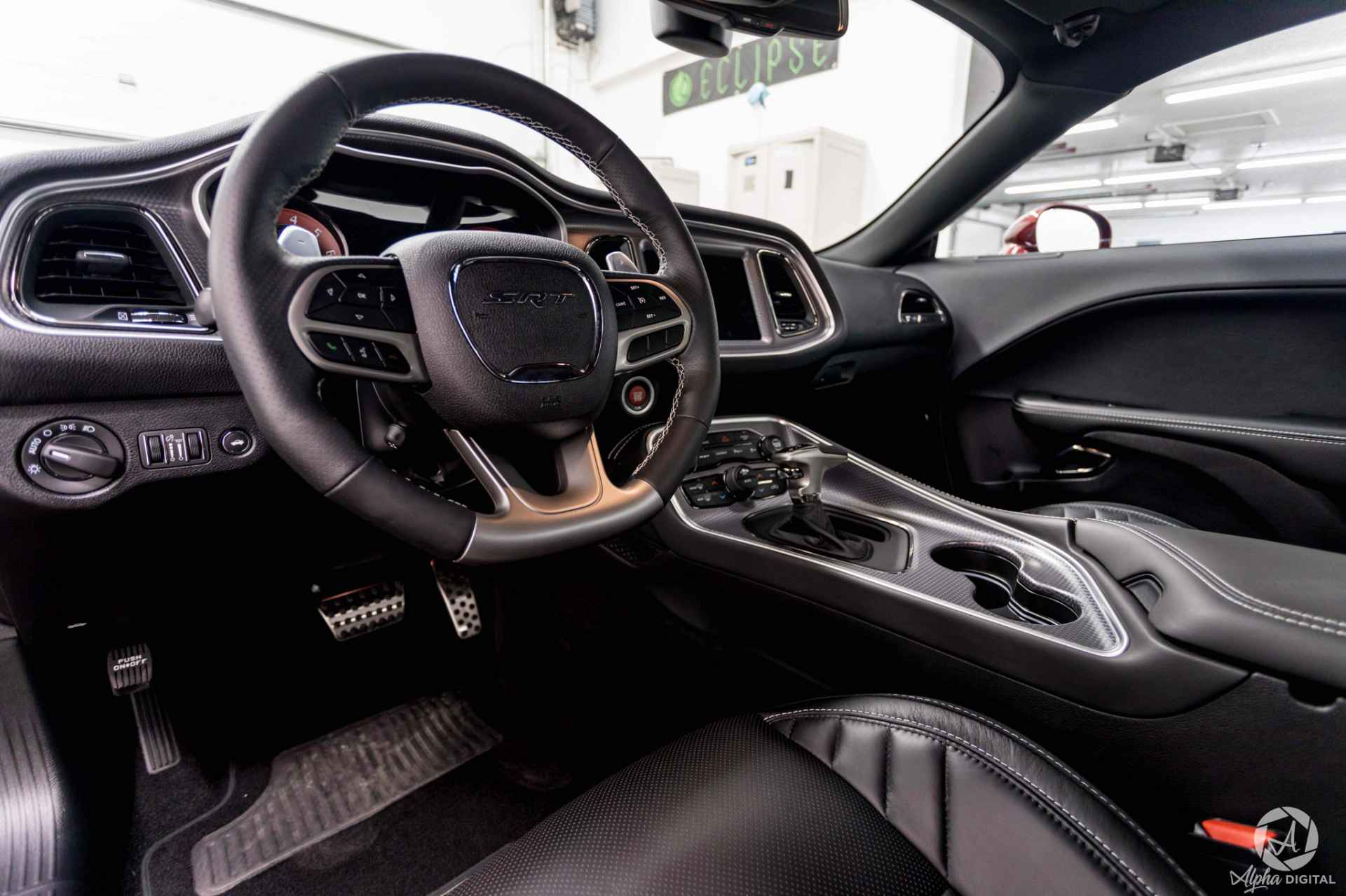 The interior of a dodge challenger is shown in a garage.
